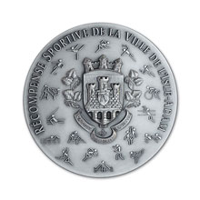 Médaille estampée avec pictogrammes, relief modelé et finition vieil argent